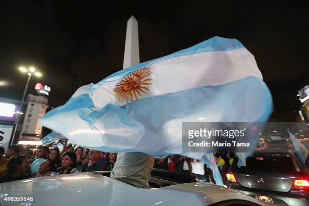 Supporters of President-elect Mauricio Macri wave Argentinian flags in the street in front of the iconic Obelisk while celebrating after he defeated...