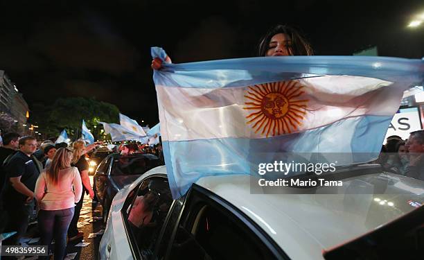 Supporters of President-elect Mauricio Macri wave flags in the street celebrating after he defeated ruling party candidate Daniel Scioli in a runoff...