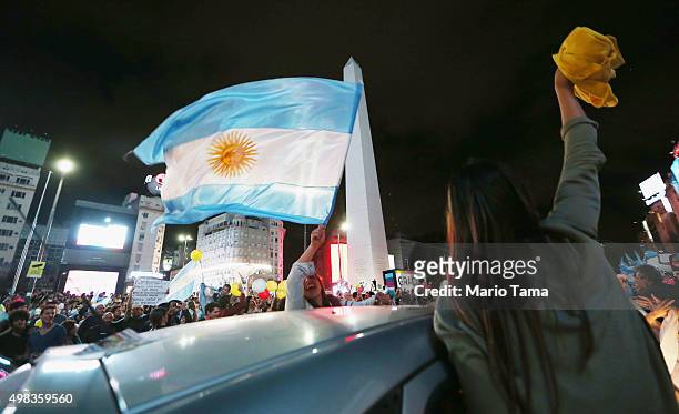 Supporters of President-elect Mauricio Macri wave Argentinian flags in the street celebrating after he defeated ruling party candidate Daniel Scioli...