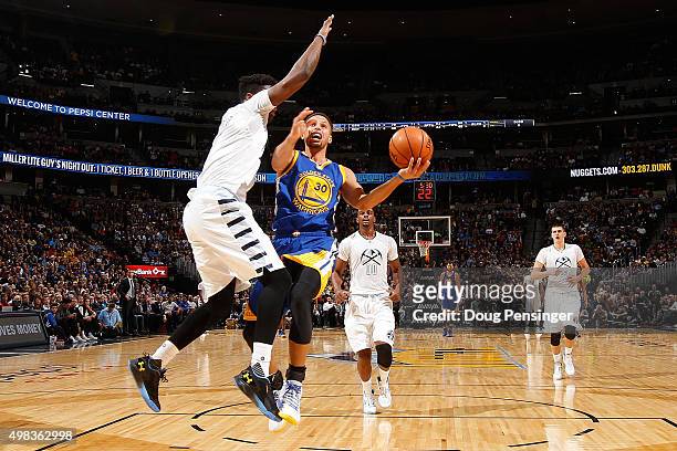 Stephen Curry of the Golden State Warriors lays up a shot against Emmanuel Mudiay of the Denver Nuggets at Pepsi Center on November 22, 2015 in...