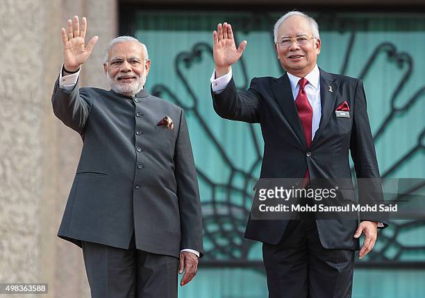 India Prime Minister Narendra Modi and Malaysia's Prime Minister Najib Razak wave to media outside the Malaysia's Prime Minister Najib Razak office...