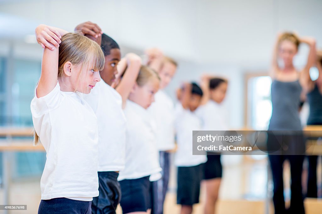 Children Stretching in Gym Class