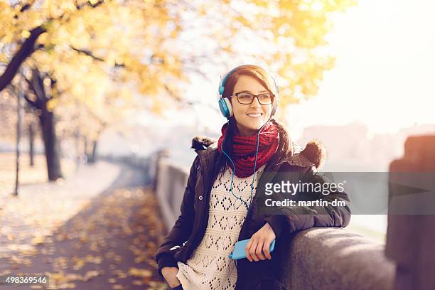 happy girl with mp3 player in the city park - krakow park stock pictures, royalty-free photos & images