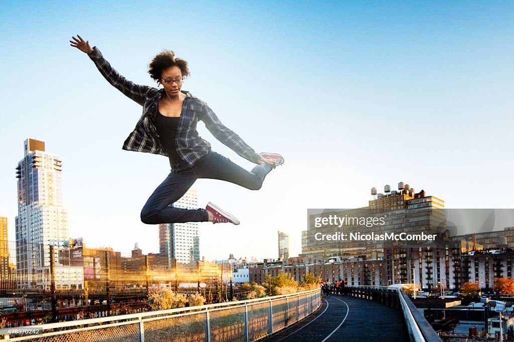 Giovane donna saltando sopra New York City High Line park