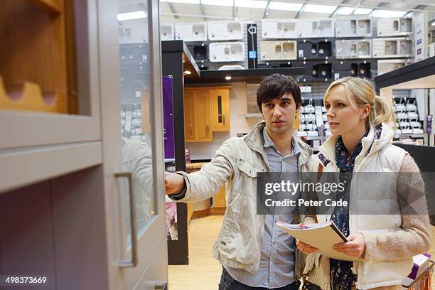 couple looking at new kitchen in showrrom - kitchen showroom stock pictures, royalty-free photos & images