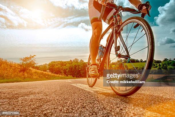 cyclist rides his bike up a steep hill - forward athlete stockfoto's en -beelden