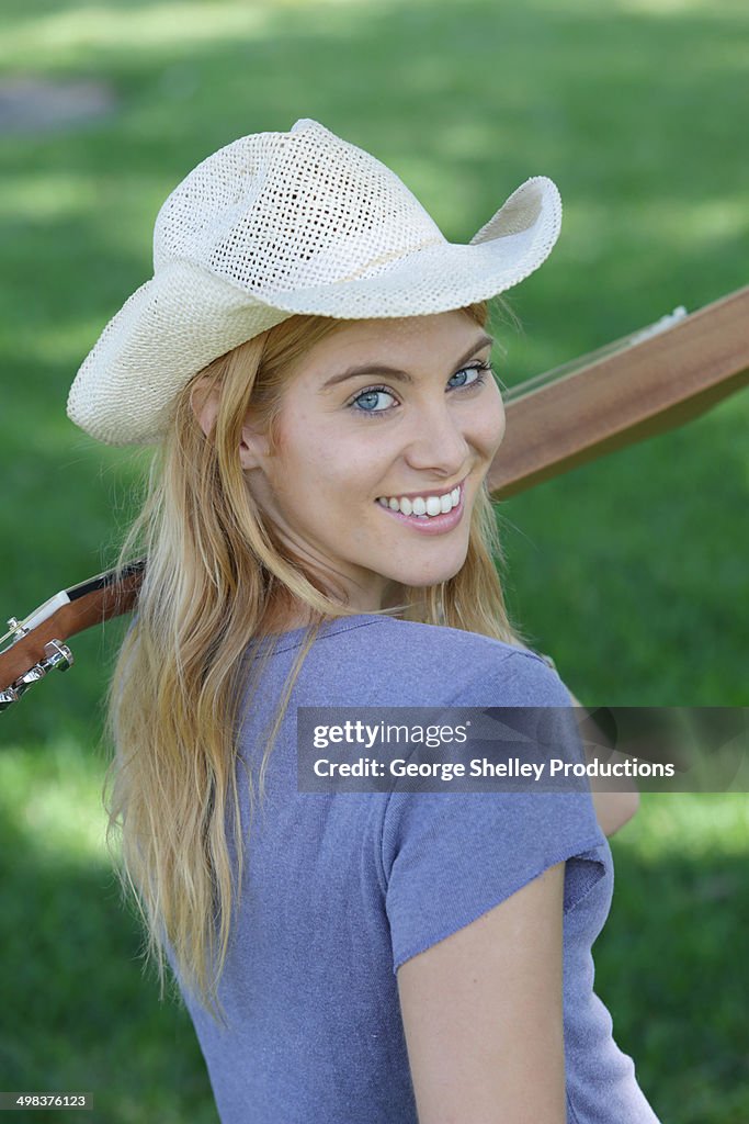 Country-western girl in a cowboy hat with guitar