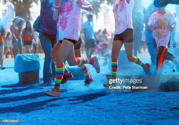 color run competitors running through blue dye - color run stock-fotos und bilder