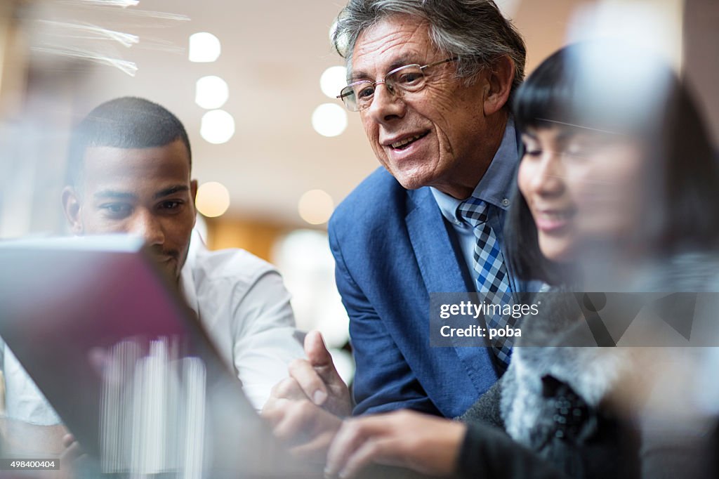 Business people with laptop meeting in lobby