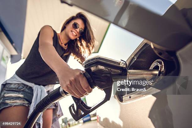 close up of a young woman at gas station. - filling stock pictures, royalty-free photos & images