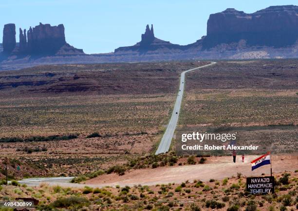 Native American children wave an American flag beside a roadside Navajo jewelry shop along a highway leading into Monument Valley Navajo Tribal Park....