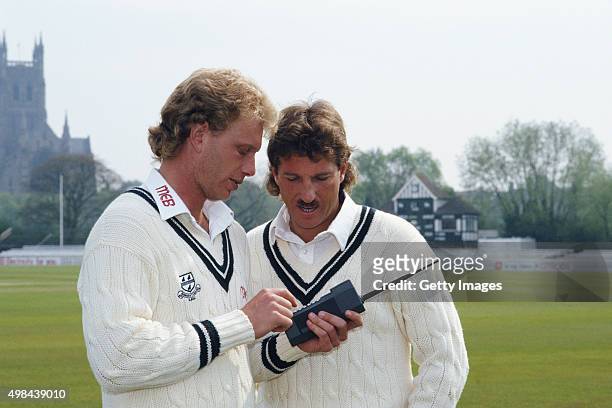 New Worcestershire signings Graham Dilley and Ian Botham with a mobile phone during the pre season photocall at New Road on April 1, 1987 in...