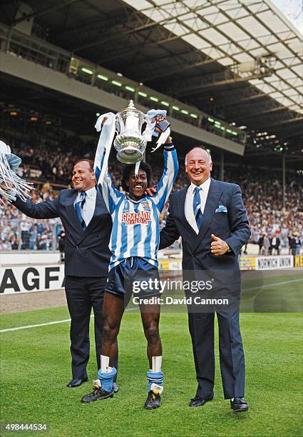 Coventry City goalscorer Dave Bennett lifts the trophy flanked by managerial team George Curtis and John Sillett after the 1987 FA Cup Final between...