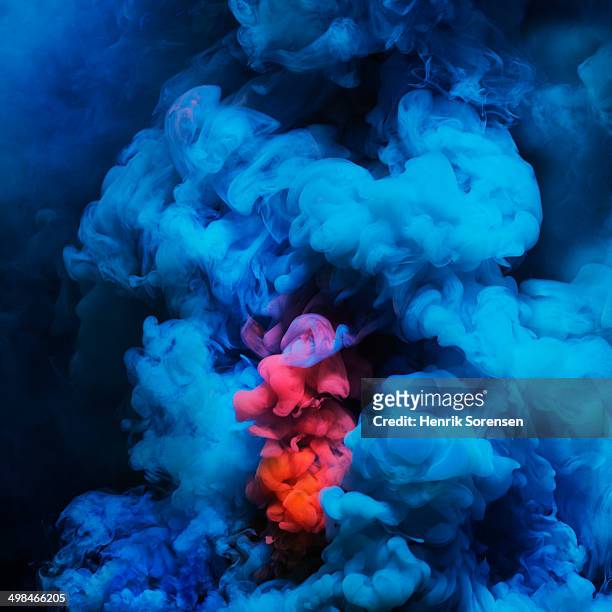 coloured smoke mixing in dark room - coloured smoke stock-fotos und bilder