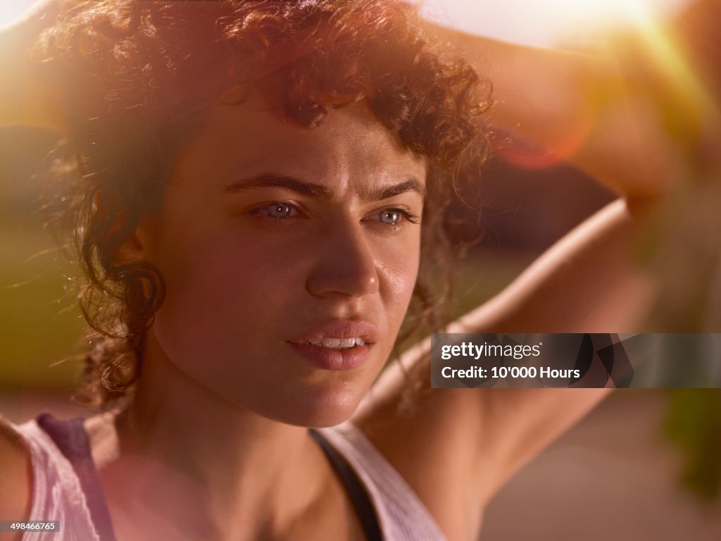 A woman tying her head back, preparing for a run