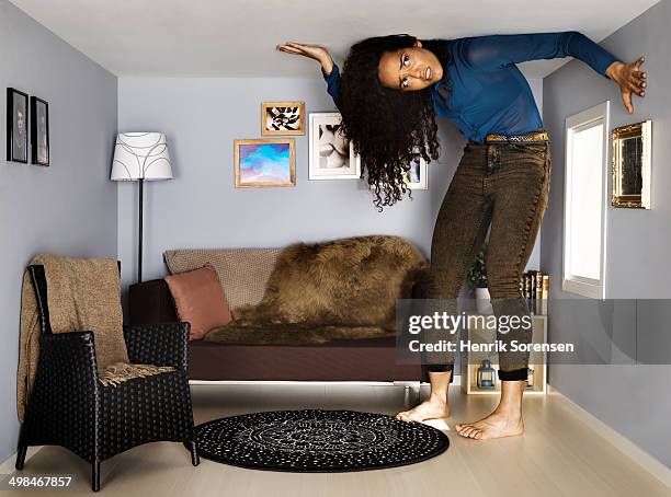 young woman in small scale living room - gevangenis stockfoto's en -beelden