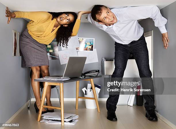 businesspeople in small office - fobie stockfoto's en -beelden