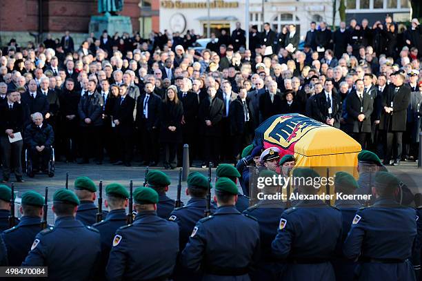 Mourners watch Pallbearers carry the coffin of former German Chancellor Helmut Schmidt out of Sankt Michaelis church following a state memorial...