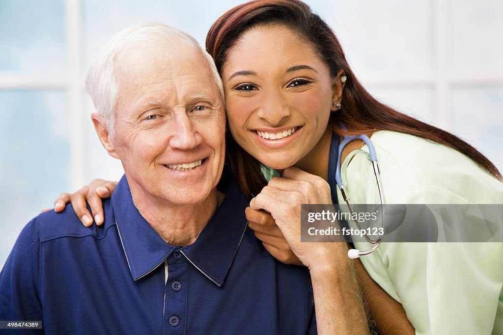 Caring, mixed-race nurse and elderly senior patient in hospital.