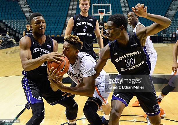 Mathieu Kamba of the Central Arkansas Bears grabs a rebound away from George Matthews of the Texas-San Antonio Roadrunners as Boo Milligan of the...