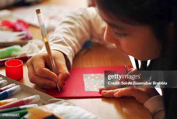 close up of a girl's hand writing a postcard - kid with markers stock-fotos und bilder