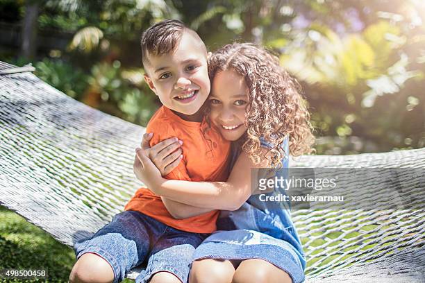 aboriginal australian siblings hugging in the garden - minority groups stock pictures, royalty-free photos & images