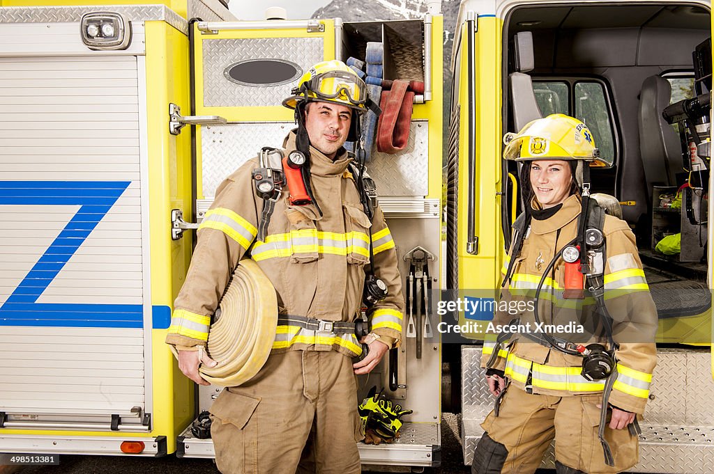 Emergency services workers stand beside fire truck