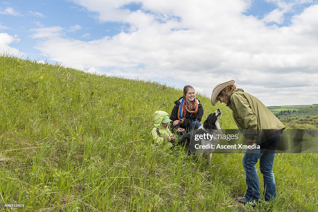 Cowgirls and sheep dog relax on open range land