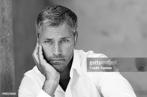 pensive man leaning on his hand - handsome people stock pictures, royalty-free photos & images