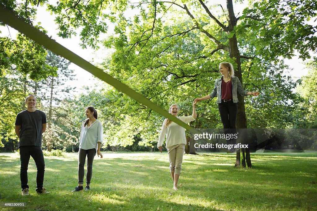 Young woman in park balancing on a slackline