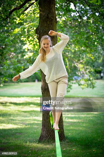 female teenager balancing on a slackline - woman tightrope stock pictures, royalty-free photos & images
