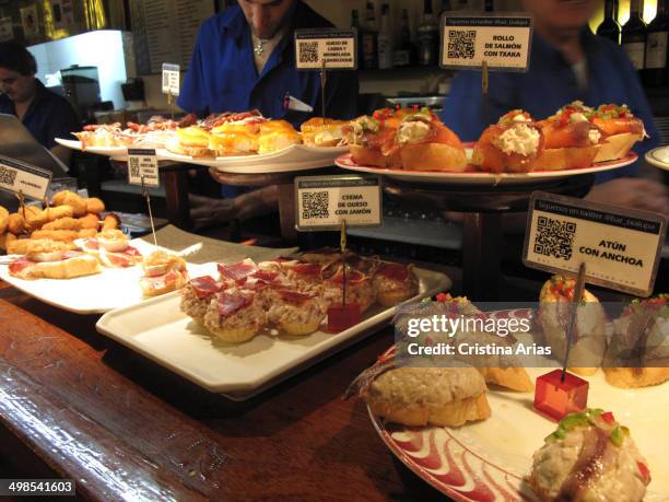 Tapas at the counter of a bar in San Sebastian, traditional and more elaborate tapas and pinchos are a small sample of the renowned Basque cuisine,...