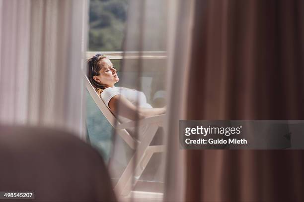 woman relaxing in the sun - achterover leunen stockfoto's en -beelden