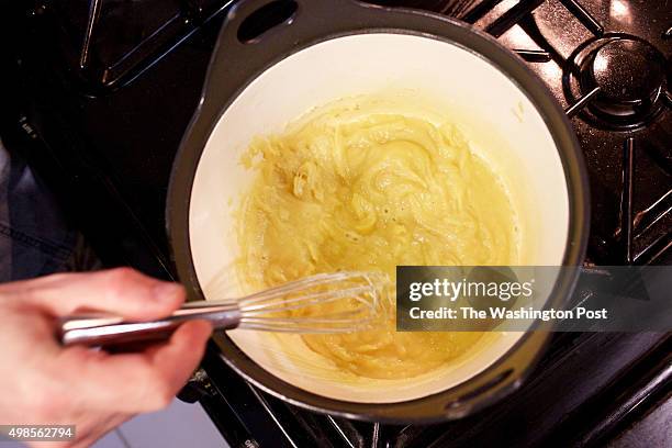 Caterer Anna Saint John's leftover creations - whisking veloute Sauce for potpie photographed in Washington, DC. .