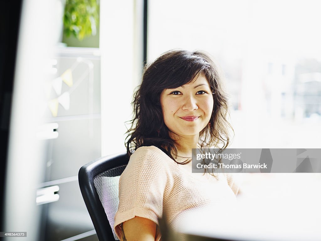 Smiling businesswoman sitting at workstation