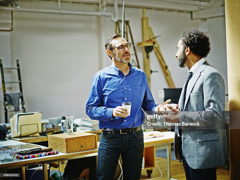 Businessmen in discussion drinking coffee