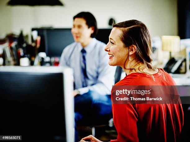 smiling businesswoman in discussion with coworkers - red dress shirt stock pictures, royalty-free photos & images