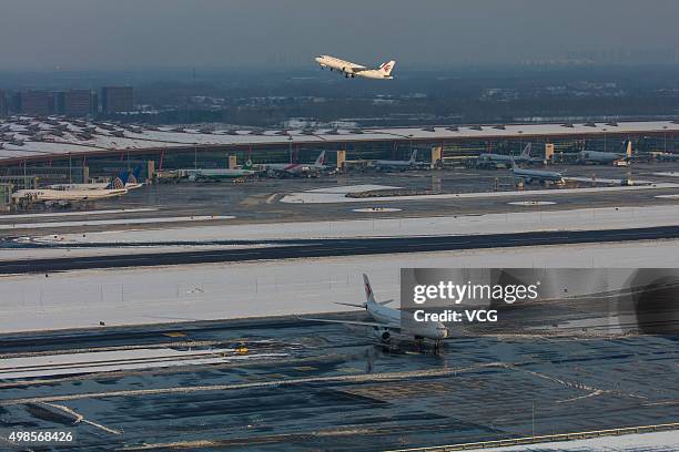 Aircraft are seen at the Beijing Capital International Airport on November 23, 2015 in Beijing, China. Workers cleared the snow at the Beijing...