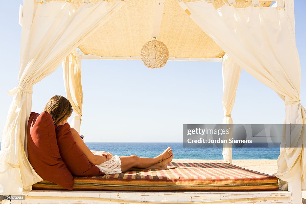 Woman laying in a cabana.