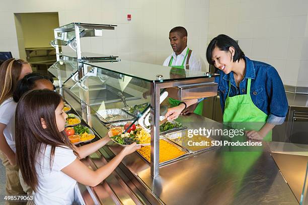 empregado do refeitório servir comida saudável para o almoço crianças na linha - empregado do refeitório imagens e fotografias de stock