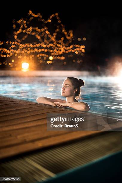 junge frau entspannung im beheizten swimmingpool im winter abend. - spa night stock-fotos und bilder