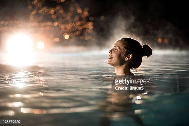 happy woman spending a winter night in heated swimming pool. - varmbadpool bildbanksfoton och bilder