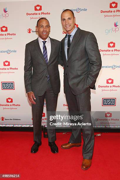 Of Global Affairs at John & Johnson, Michael Sneed and celebrity photographer Nigel Barker attend "Donate A Photo" holiday kick-off event at The...