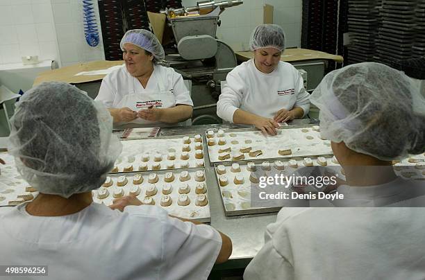 Women pack freshy made polvorones at the Turrones Primitivo Rovira factory on November 24, 2015 in Jijona, Spain. Turron, a nougat confection of...