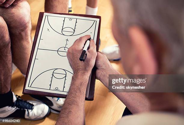 close-up of coach making basketball strategy. - coach clipboard stock pictures, royalty-free photos & images