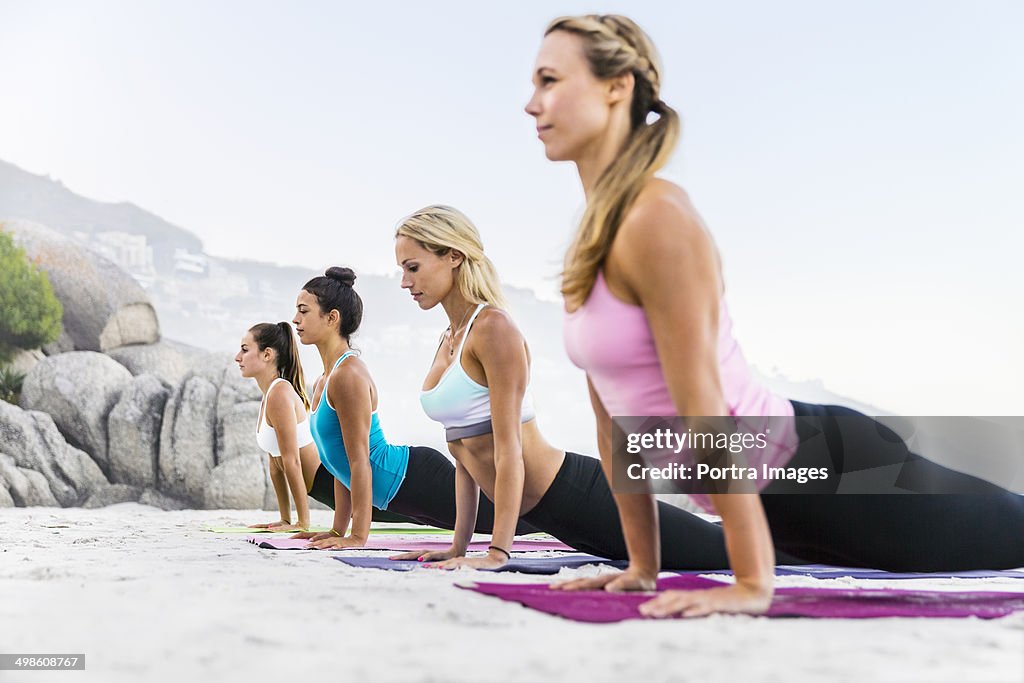 Women doing physical yoga exercise outdoors.