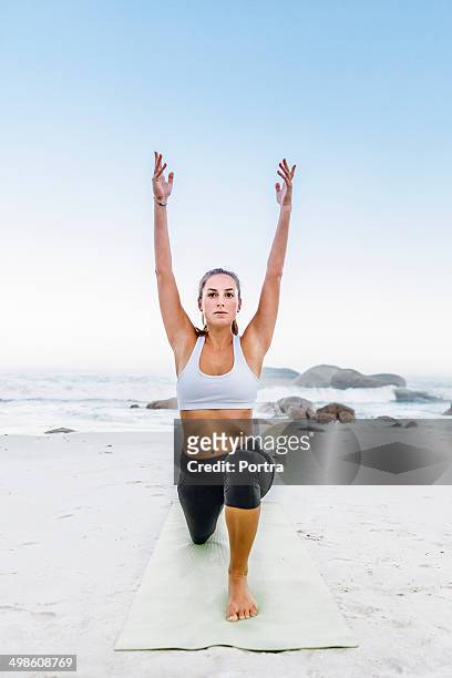 young athletic woman doing exercise on the beach. - beach yoga stock-fotos und bilder