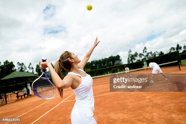 mujer jugando al tenis - sacada fotografías e imágenes de stock