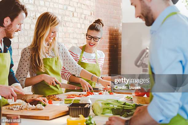 four people taking part in cooking class - cooking school stock pictures, royalty-free photos & images