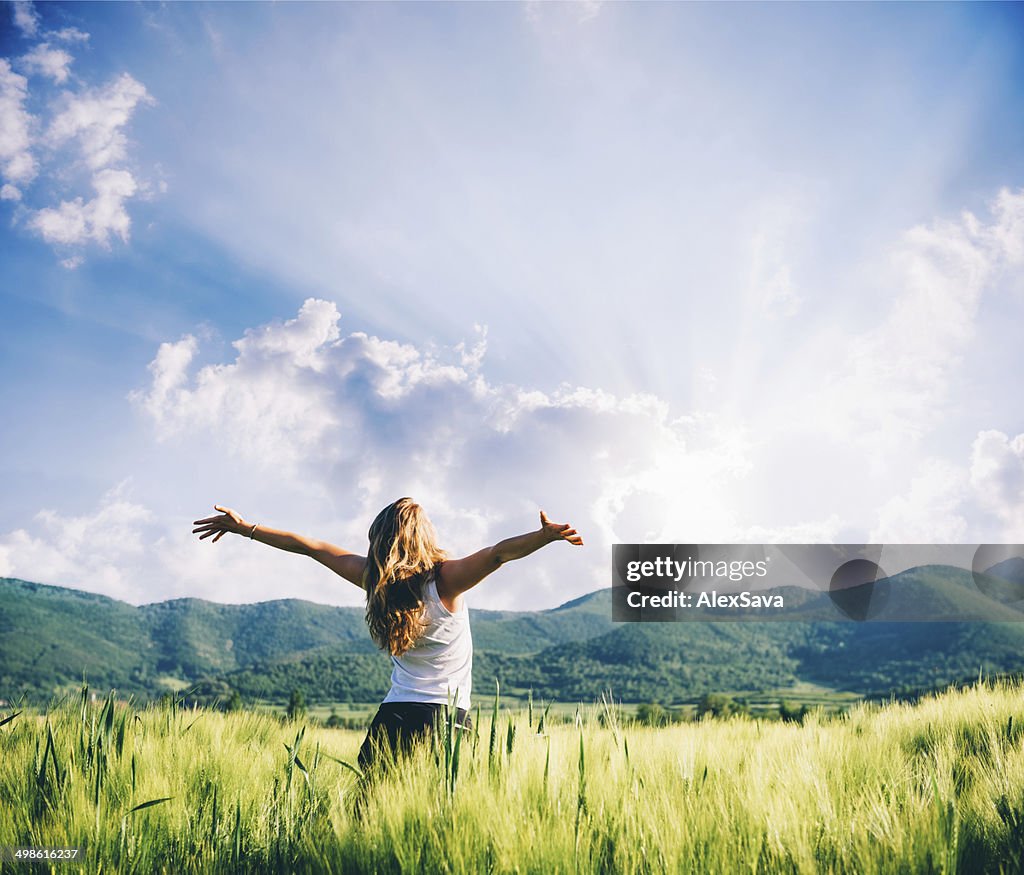 View of a woman in the wheat field beeing happy